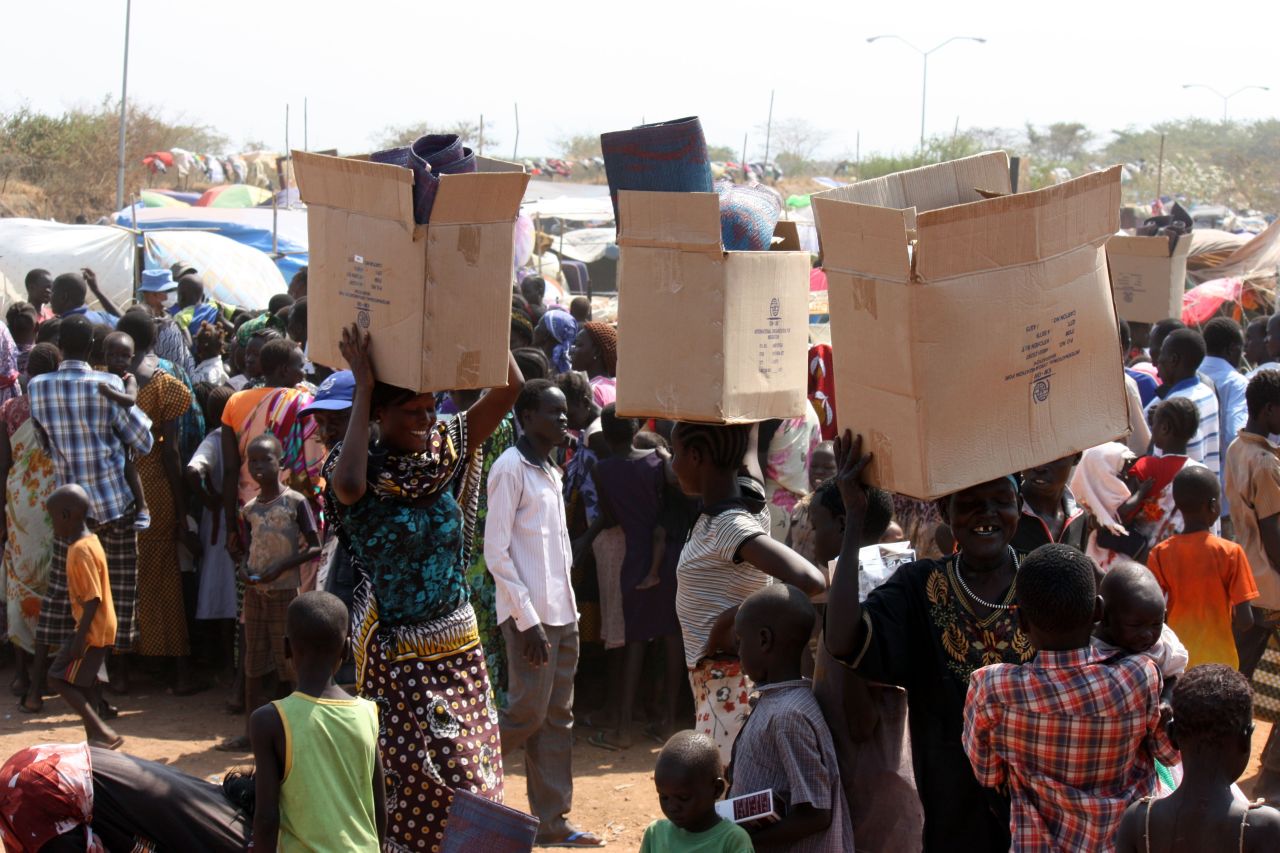 South Sudanese refugees carry relief supplies an a U.N. camp in Juba on Sunday, December 29. 