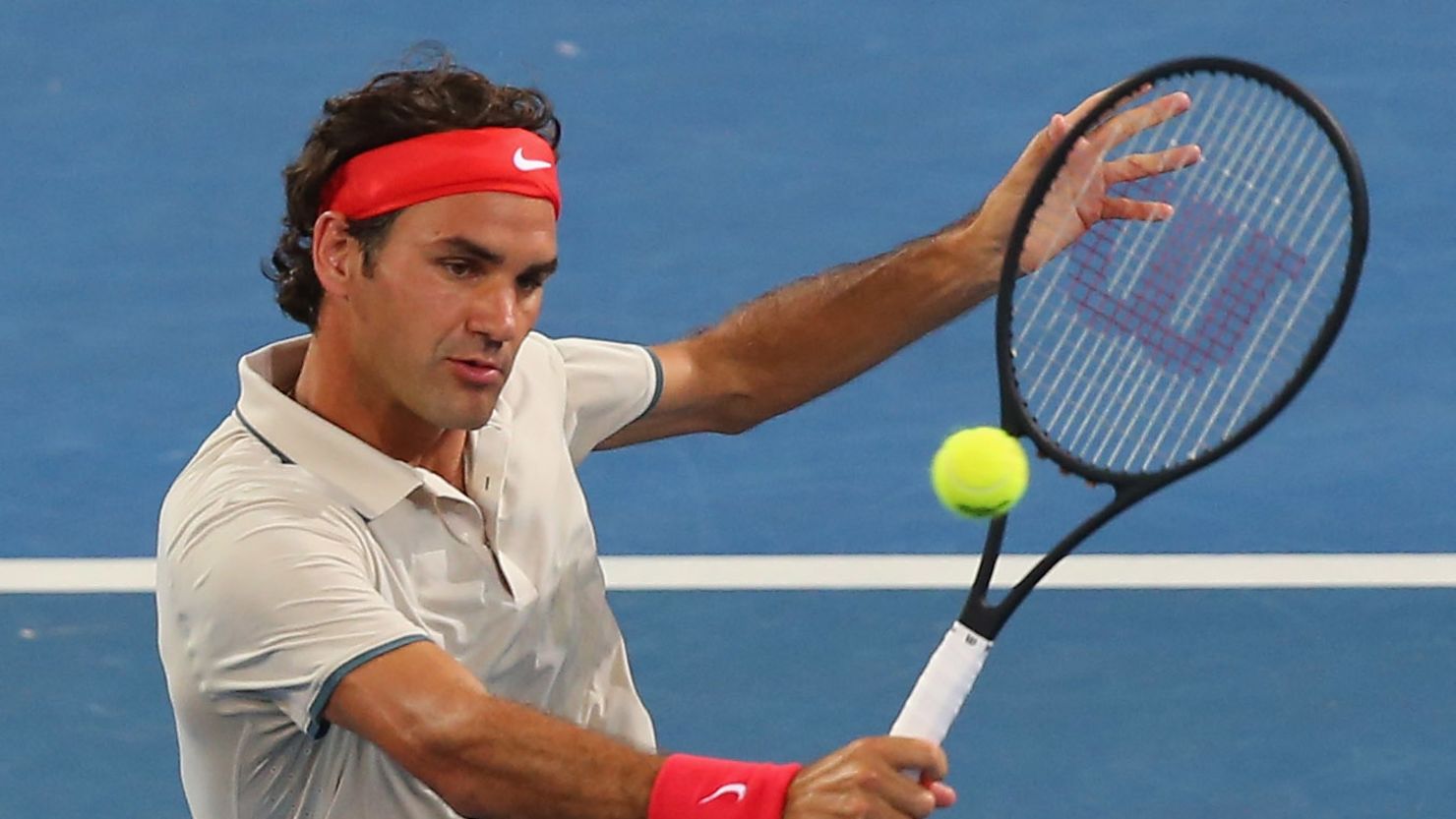 Roger Federer in action in a doubles match in Brisbane using a racket with a bigger head.  