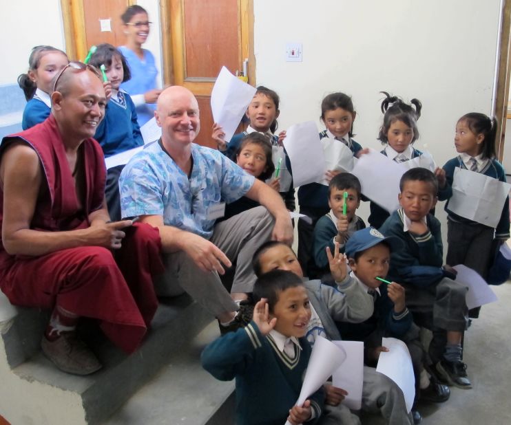 Dentist Raymond Broussard, center, relaxes with kids he examined at the volunteer clinic in Leh.