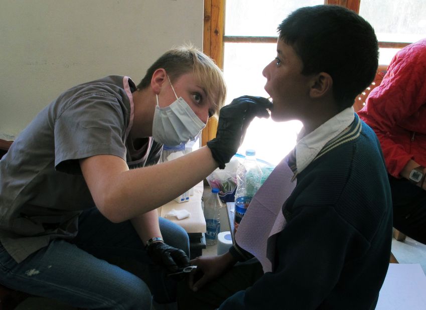 Larkin Broussard, left, applies fluoride to a boy's teeth at the makeshift dental clinic in Leh.