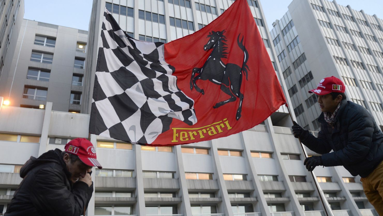 Fans hold a Ferrari flag Tuesday in front of the Grenoble University Hospital Center.