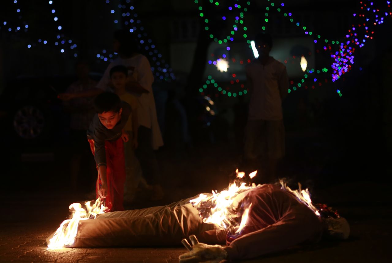 In Mumbai, an Indian boy lights the effigy of an old man, symbolizing the burning of the past in hopes of starting a new year without bad memories.