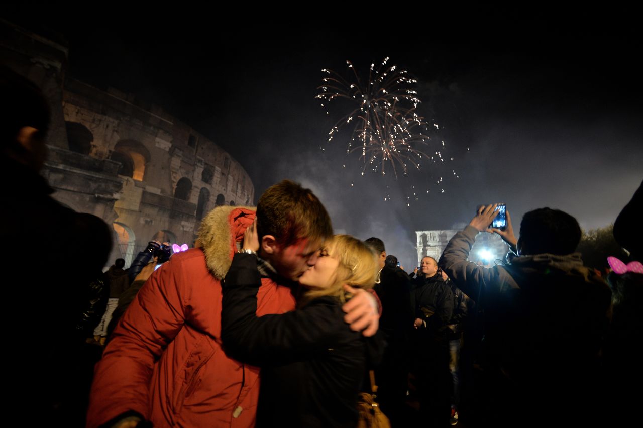 A couple kisses by the ancient Coliseum to celebrate the new year in Rome.