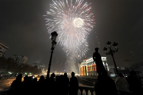 People watch fireworks explode over the Vardar River during New Year's celebrations in Skopje, Macedonia.
