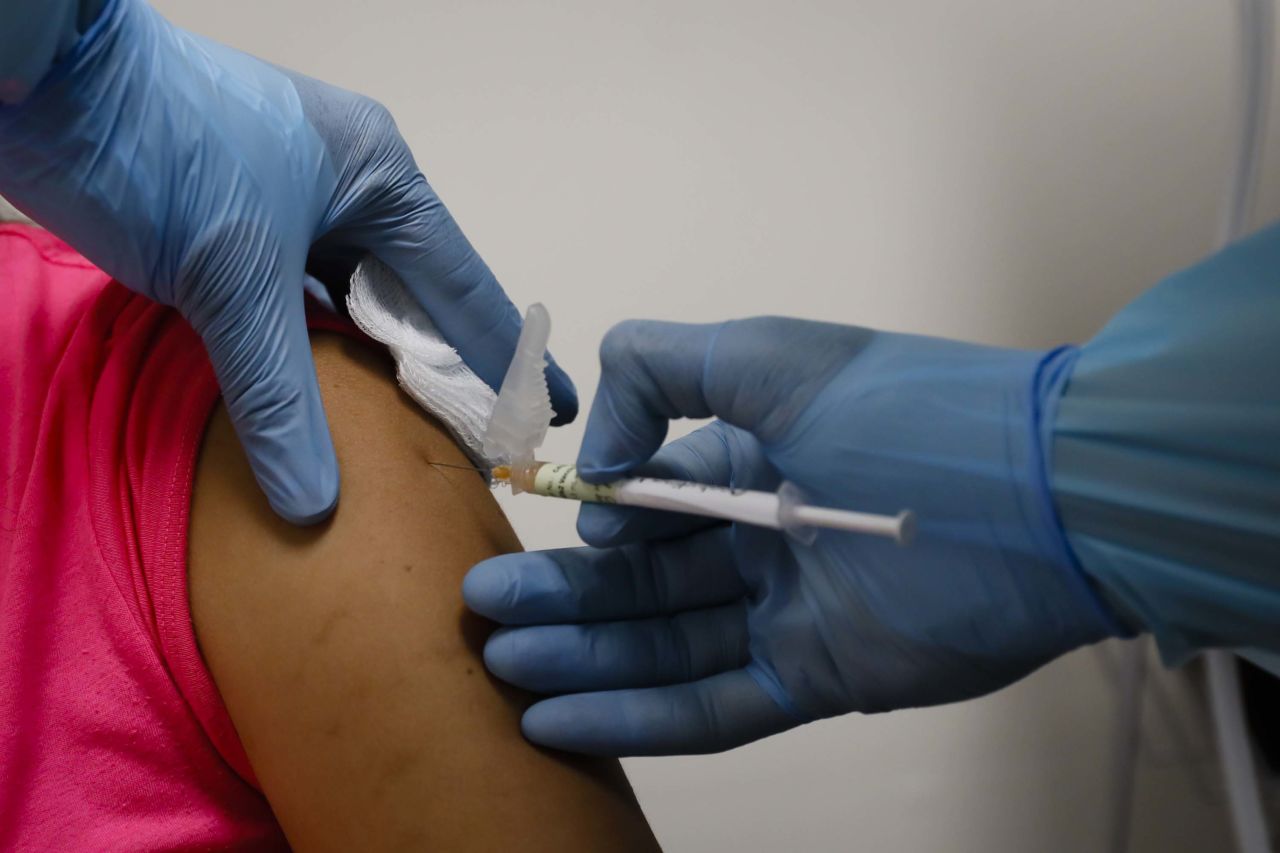 A health worker injects a woman during clinical trials for Pfizer's Covid-19 vaccine at Research Centers of America in Hollywood, Florida, on September 9.