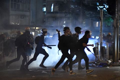 Protesters run as police fire tear gas at them in Wong Tai Sin during a general strike in Hong Kong on August 5.