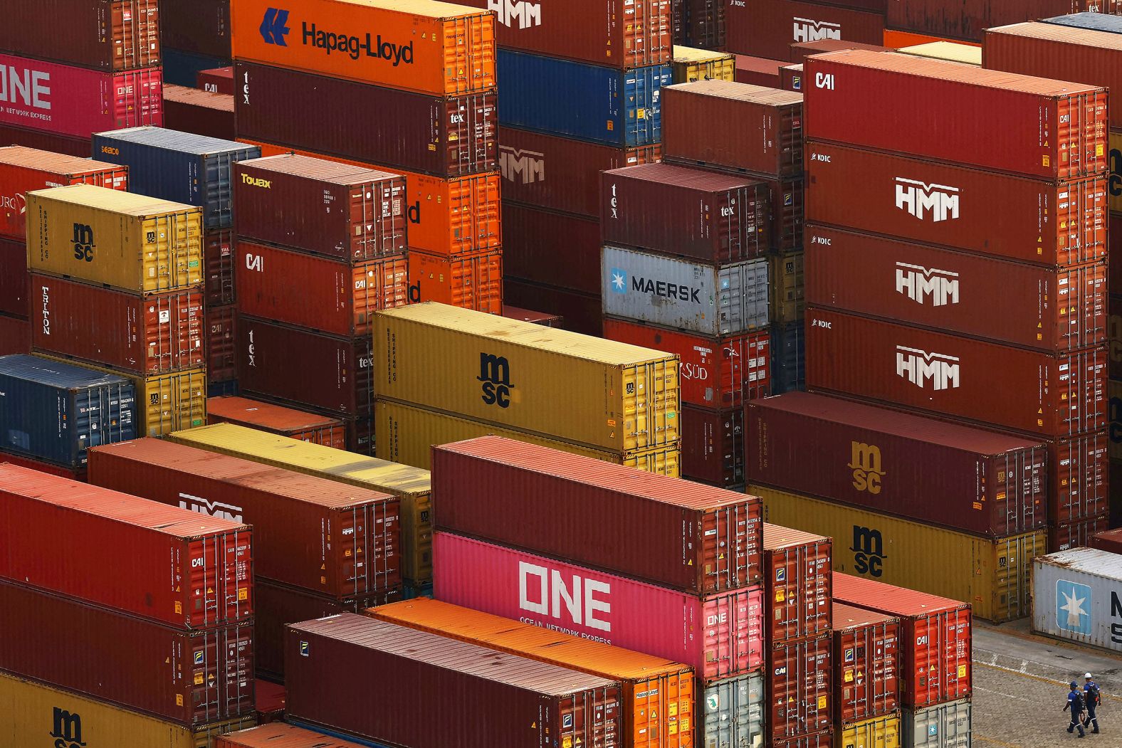 Workers walk next to containers in Brazil’s Port of Rio Grande on Tuesday, May 6.