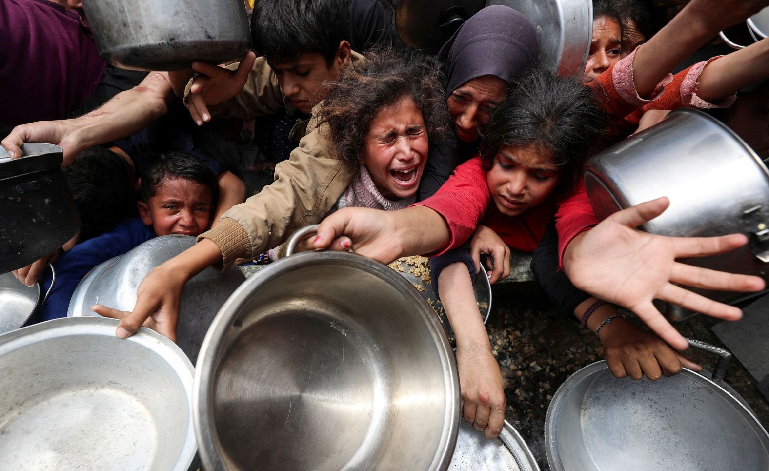 Palestinians wait to receive food cooked by a charity kitchen in Jabalya, Gaza, on Wednesday, May 14. <a href="index.php?page=&url=https%3A%2F%2Fwww.cnn.com%2F2025%2F05%2F13%2Fmiddleeast%2Fisrael-gaza-starvation-report-intl-hnk">One in five people in Gaza are facing starvation</a> as the entire territory edges closer to famine, a new United Nations-backed report warned.