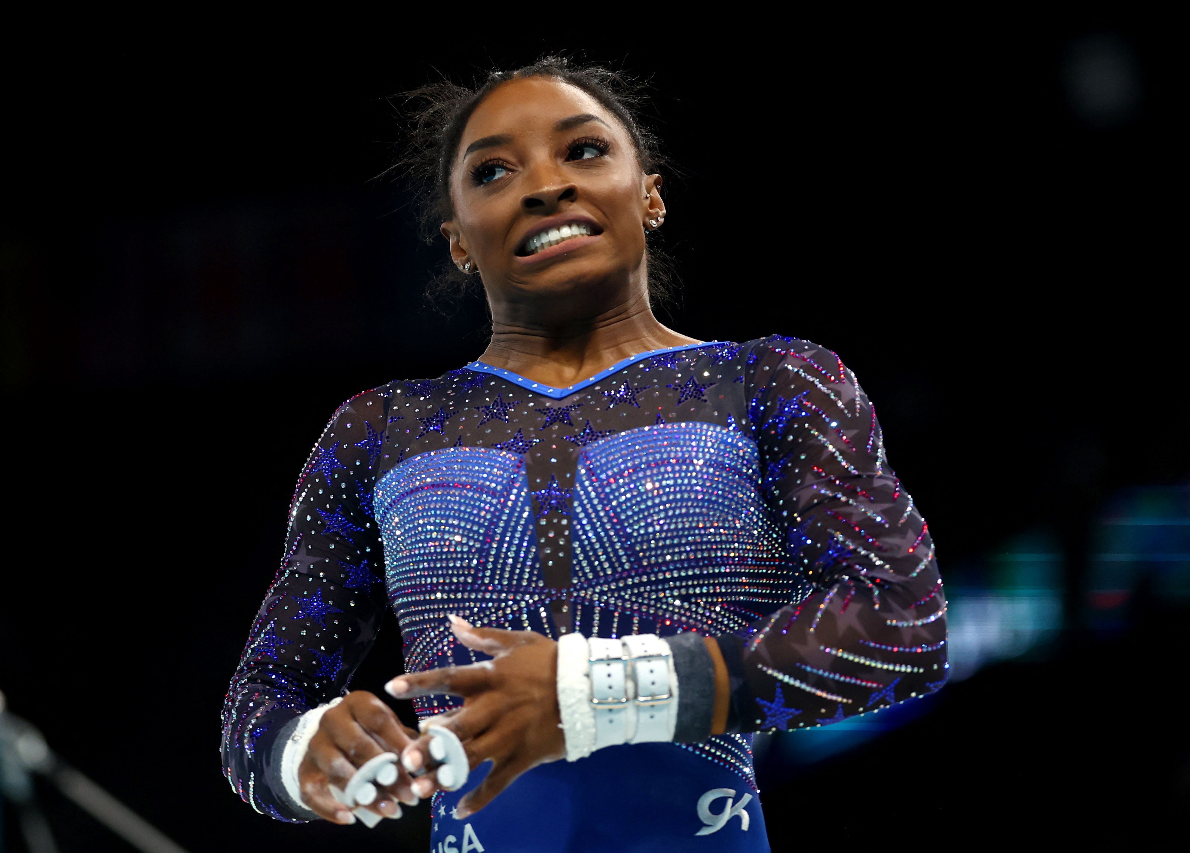 Biles reacts after her performance on the uneven bars. She was in third place halfway through the all-around. Andrade was in first.