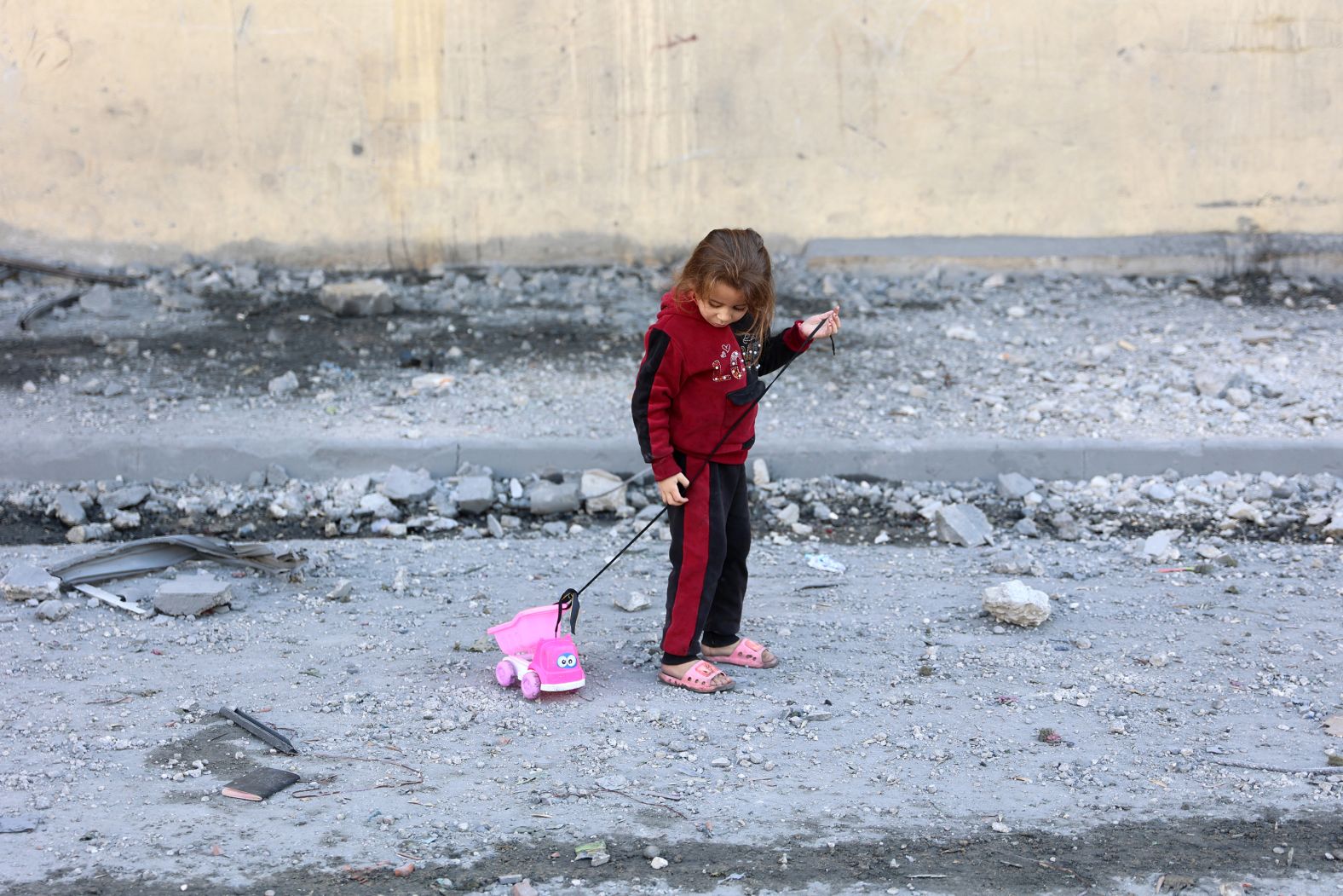 A Palestinian girl pulls on a toy on a debris-filled street in Jabalya, Gaza, on Wednesday, November 20. Fares Afana, the head of emergency services in northern Gaza, told CNN last month that there are “thousands of children” and pregnant women stuck in the <a href="index.php?page=&url=https%3A%2F%2Fwww.cnn.com%2F2024%2F10%2F16%2Fmiddleeast%2Fisraeli-incursion-northern-gaza-stray-dogs-eating-bodies-intl%2Findex.html">besieged area</a>, where the Israeli military has carried out aerial and ground attacks. The Israel Defense Forces said it was targeting Hamas’ renewed presence there.