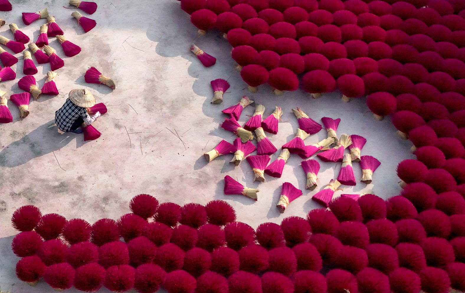 A worker arranges dried incense sticks to dry in a courtyard in Quang Phu Cau village, Vietnam, on Tuesday. Incense burning is a Lunar New Year tradition, symbolizing prayers for prosperity and good fortune.