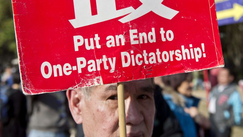 A protester holds a banner during a pro-democracy demonstration in Hong Kong on January 1, 2014. Tens of thousands of people rallied in Hong Kong to call for universal suffrage, as the city grapples with how its future leaders will be chosen under a long-awaited political reform. AFP PHOTO / ALEX OGLEAlex Ogle/AFP/Getty Images