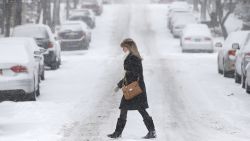 A pedestrian walks through morning snow, Thursday, Jan. 2, 2014, in Albany, N.Y. Snow and bone-chilling temperatures are greeting morning commuters across New York on the first work day of 2014, with some upstate areas expected to get more than a foot of snow by the weekend. (AP Photo/Mike Groll)