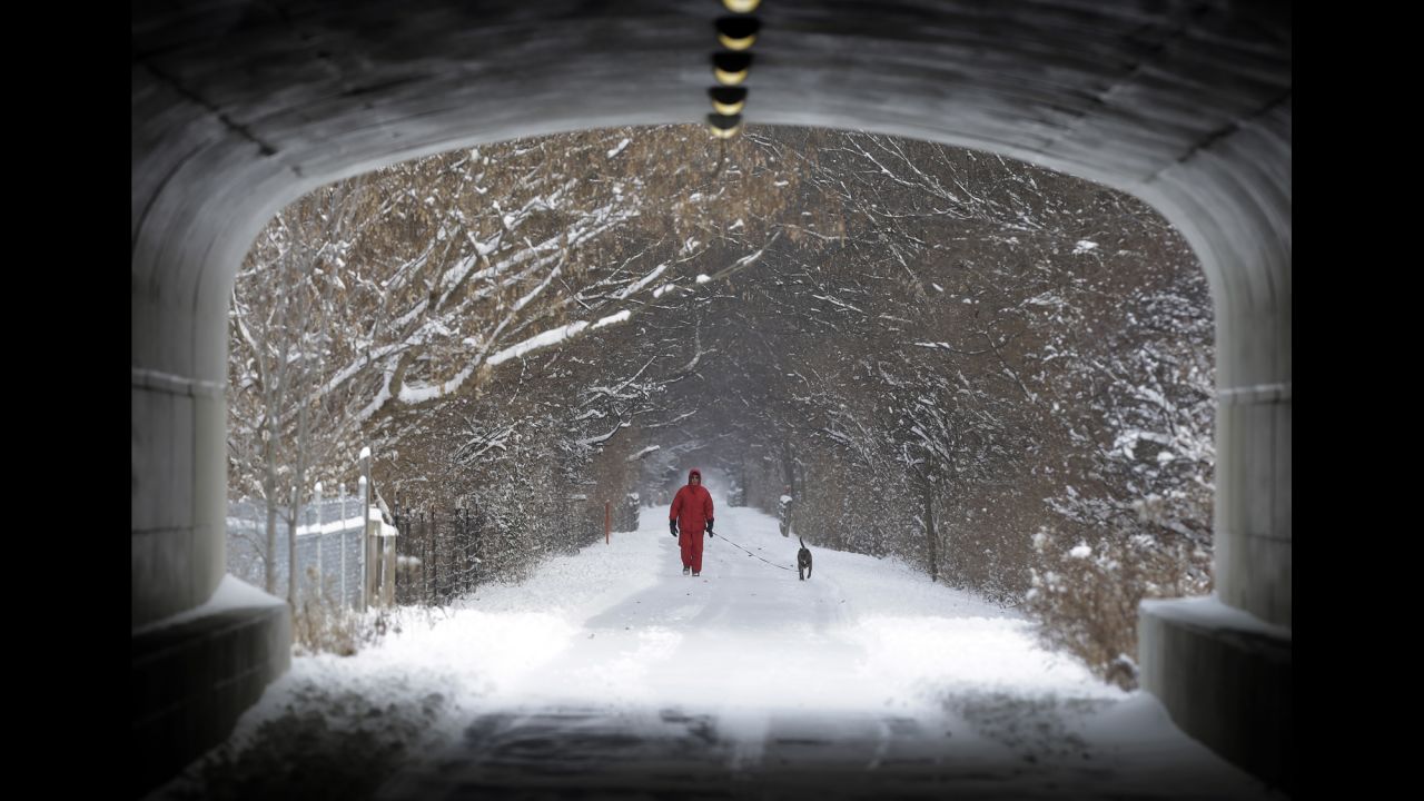 A man walks his dog on the snow-covered Monon Trail in Carmel, Indiana, on January 2.