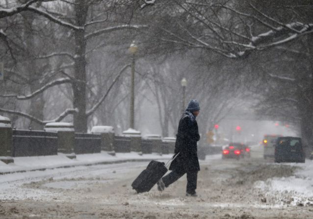 A man drags a suitcase on a snowy street in downtown Boston on January 2.