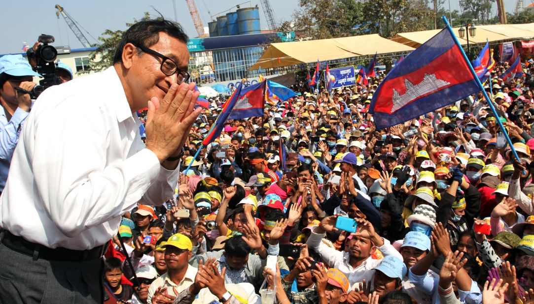 Leader of the opposition Cambodia National Rescue Party (CNRP) Sam Rainsy greets supporters during a demonstration in Phnom Penh on December 29, 2013.