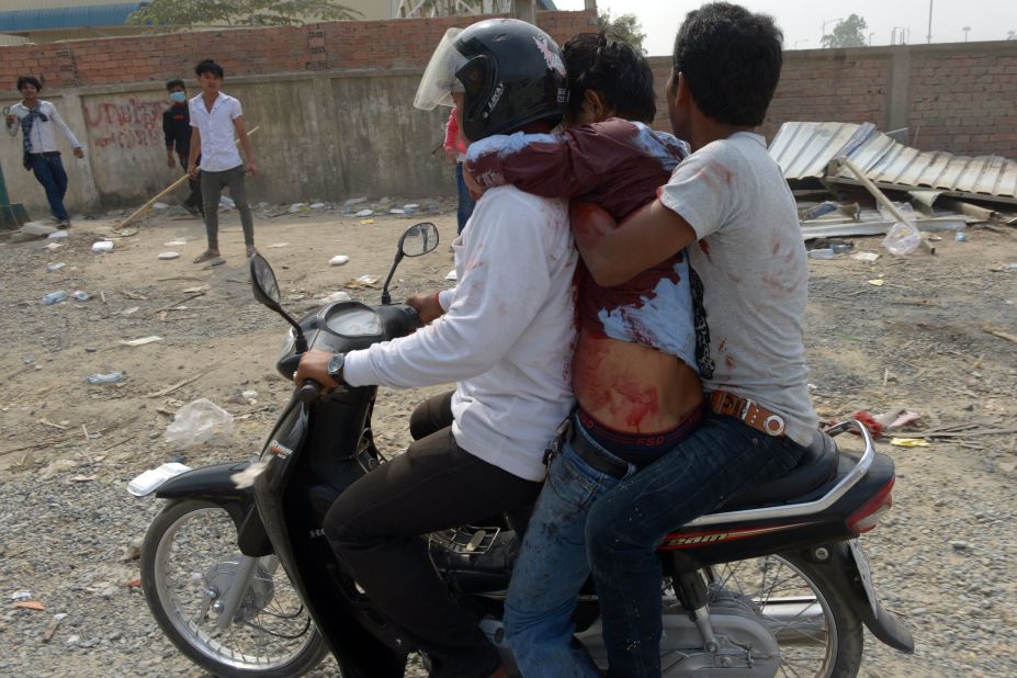 Cambodian workers transport a man who was injured during a confrontation with military police on Friday.