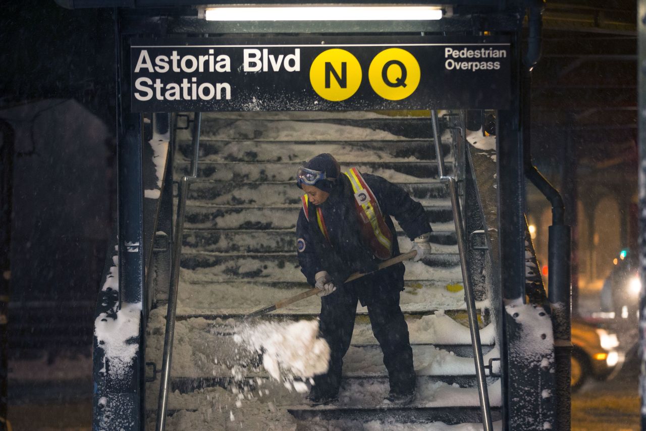 A worker clears snow from a subway station in Queens, New York, on January 3. Public schools were closed Friday after up to 7 inches of snow fell in New York City.