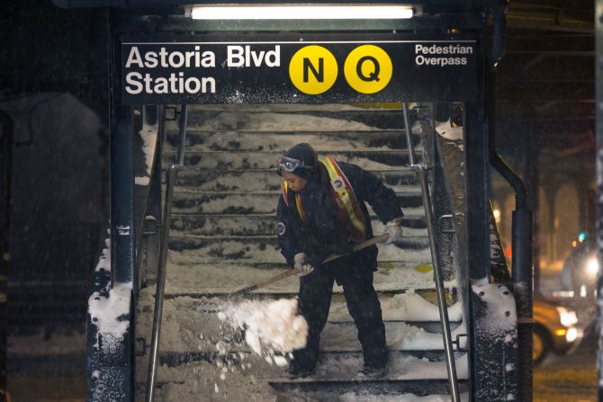 A worker clears snow from a subway station in Queens, New York, on January 3. Public schools were closed Friday after up to 7 inches of snow fell in New York City.