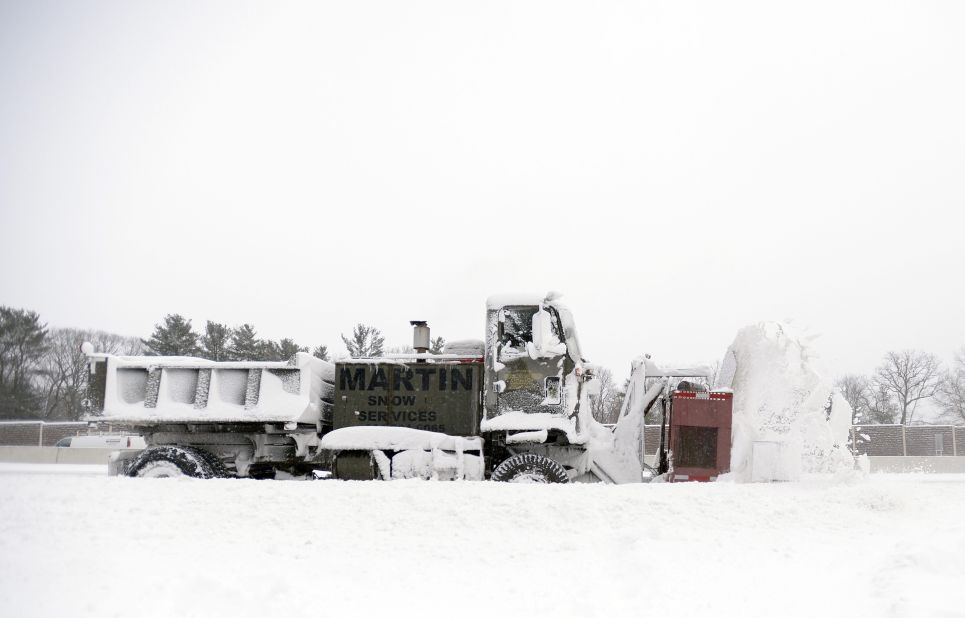 A truck-mounted snowblower clears a section of road in Dedham, Massachusetts, on January 3.