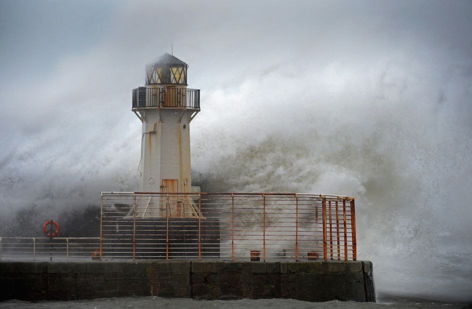 Waves crash over the Ardrossan Harbor Lighthouse in Ardrossan, Scotland, on January 3.