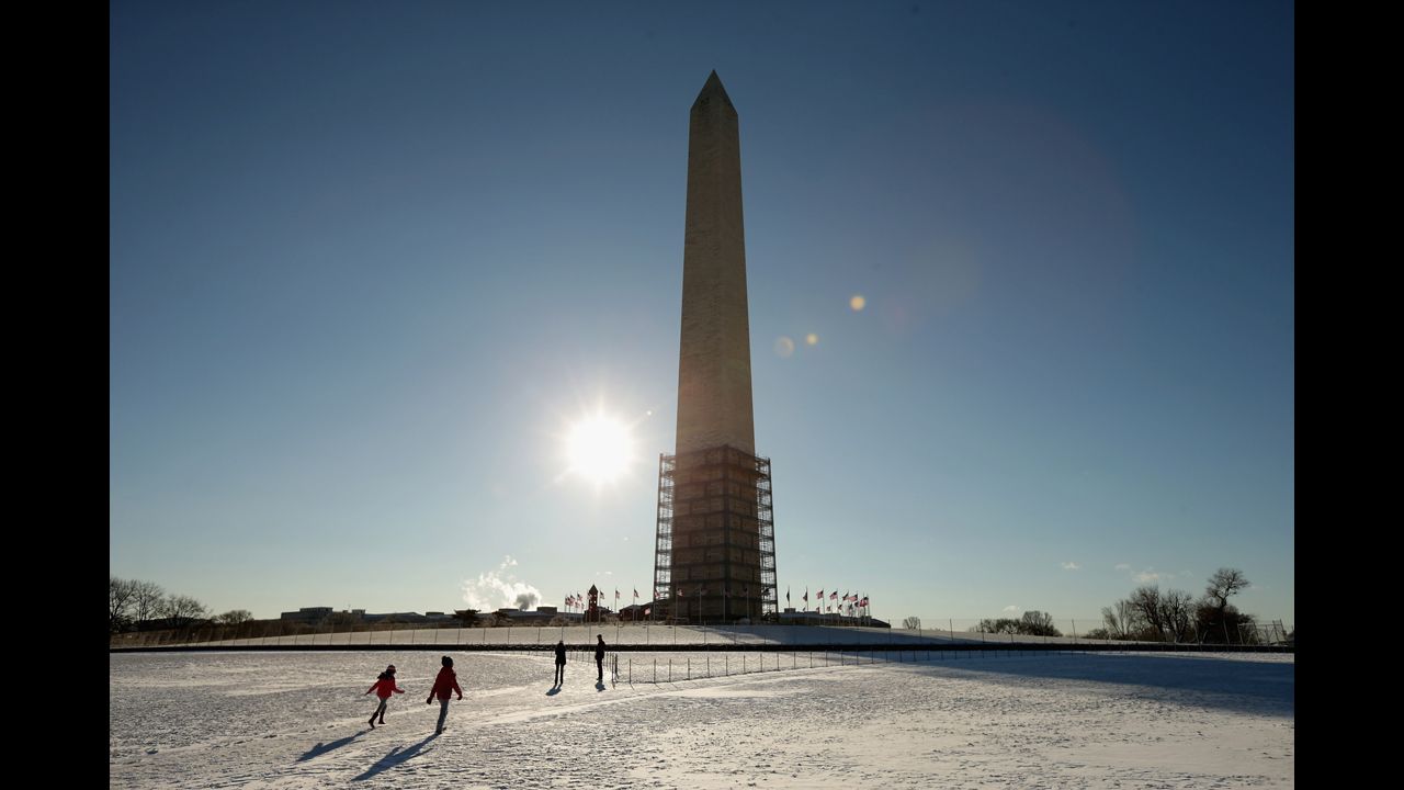 Tourists play in the snow at the base of the Washington Monument on January 3.