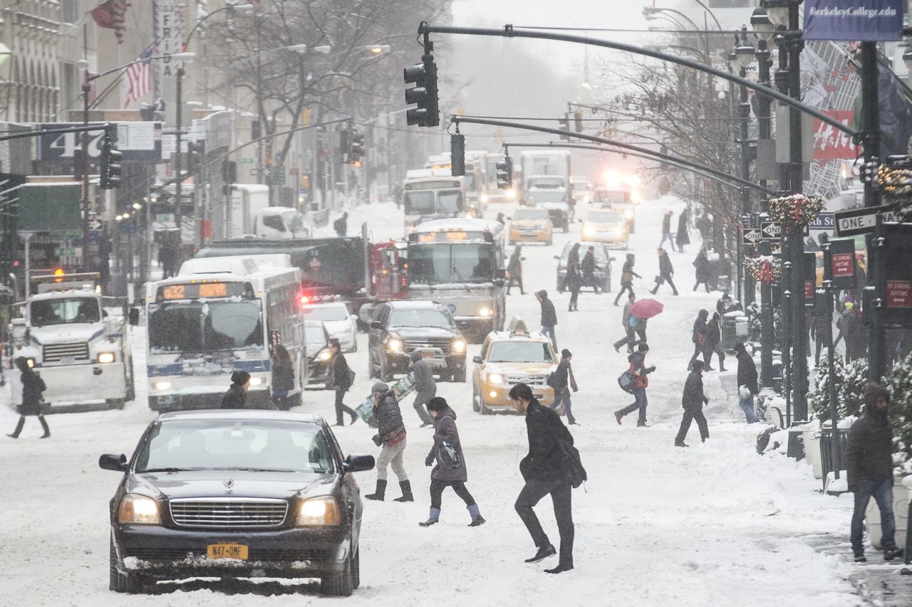 Pedestrians brave wind and snow as they cross New York City's Fifth Avenue on January 3.