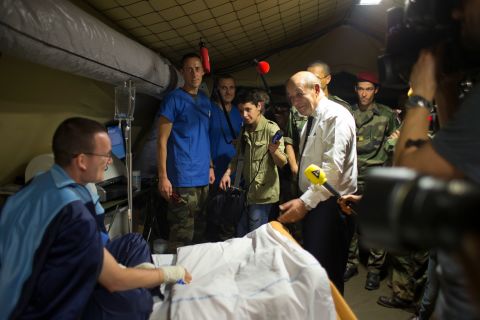 French Defense Minister Jean-Yves Le Drian, center right, speaks to a wounded soldier in a medical tent during a visit to the M'Poko Camp in Bangui on Thursday, January 2. France has sent 1,600 troops into the Central African Republic to assist African troops.