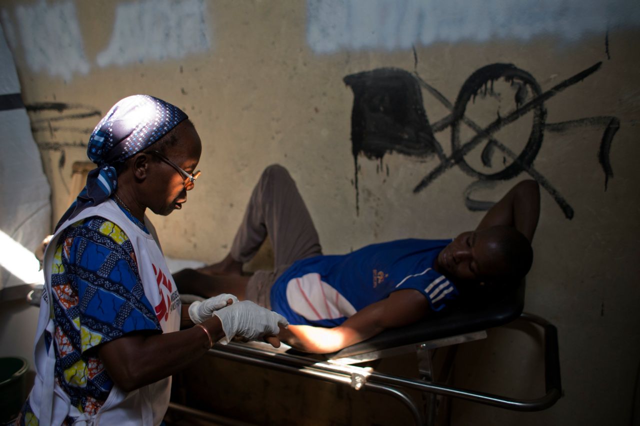 A medical worker checks the injuries of a man who has been struck by gunfire. The man was treated at a Doctors Without Borders clinic inside a makeshift camp in Bangui on January 2.