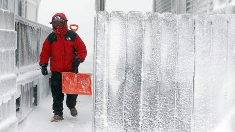 Michael Stanton walks between houses covered with ice in Scituate, Massachusetts, on January 3.