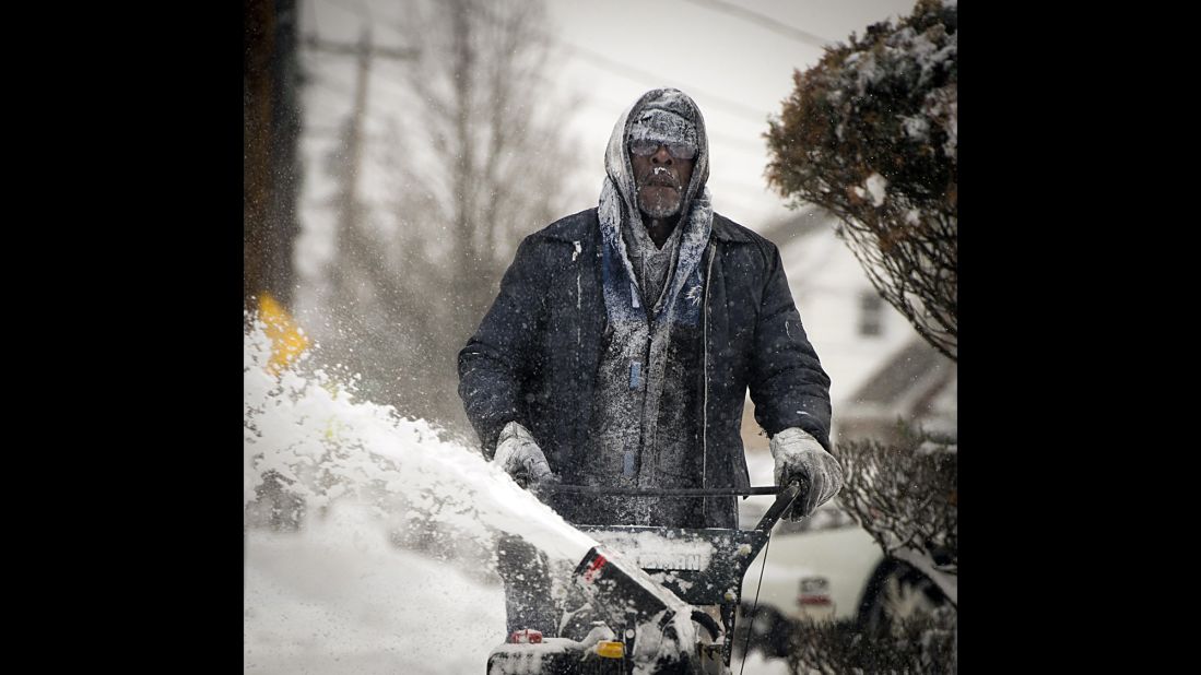 Snow clings to the clothing and facial hair of Jerome Williams as he uses a snowblower in front of his home in Roosevelt, New York, on January 3.
