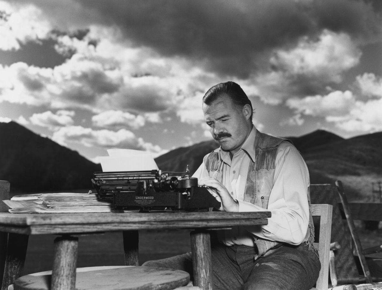 Ernest Hemingway, who wrote "For Whom the Bell Tolls" and "The Old Man and the Sea," works at his typewriter while sitting outdoors in 1939.