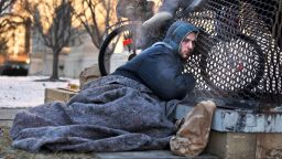 Nick warms himself on a steam grate with three other homeless men by the Federal Trade Commission, just blocks from the Capitol, during frigid temperatures in Washington, Saturday, Jan. 4, 2014. A winter storm that swept across the Midwest this week blew through the Northeast on Friday, leaving bone-chilling cold in its wake. (AP Photo/Jacquelyn Martin)