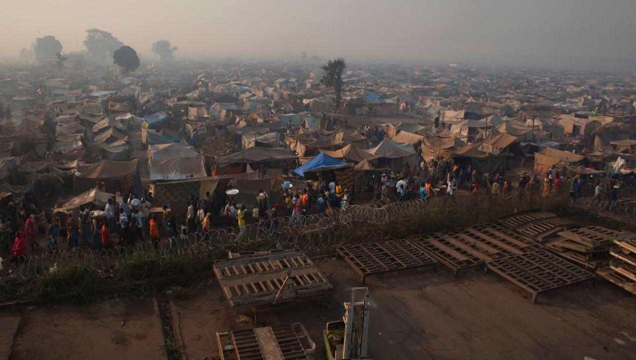 Displaced people walk amid makeshift shelters at a camp abutting M'Poko International Airport on January 4.