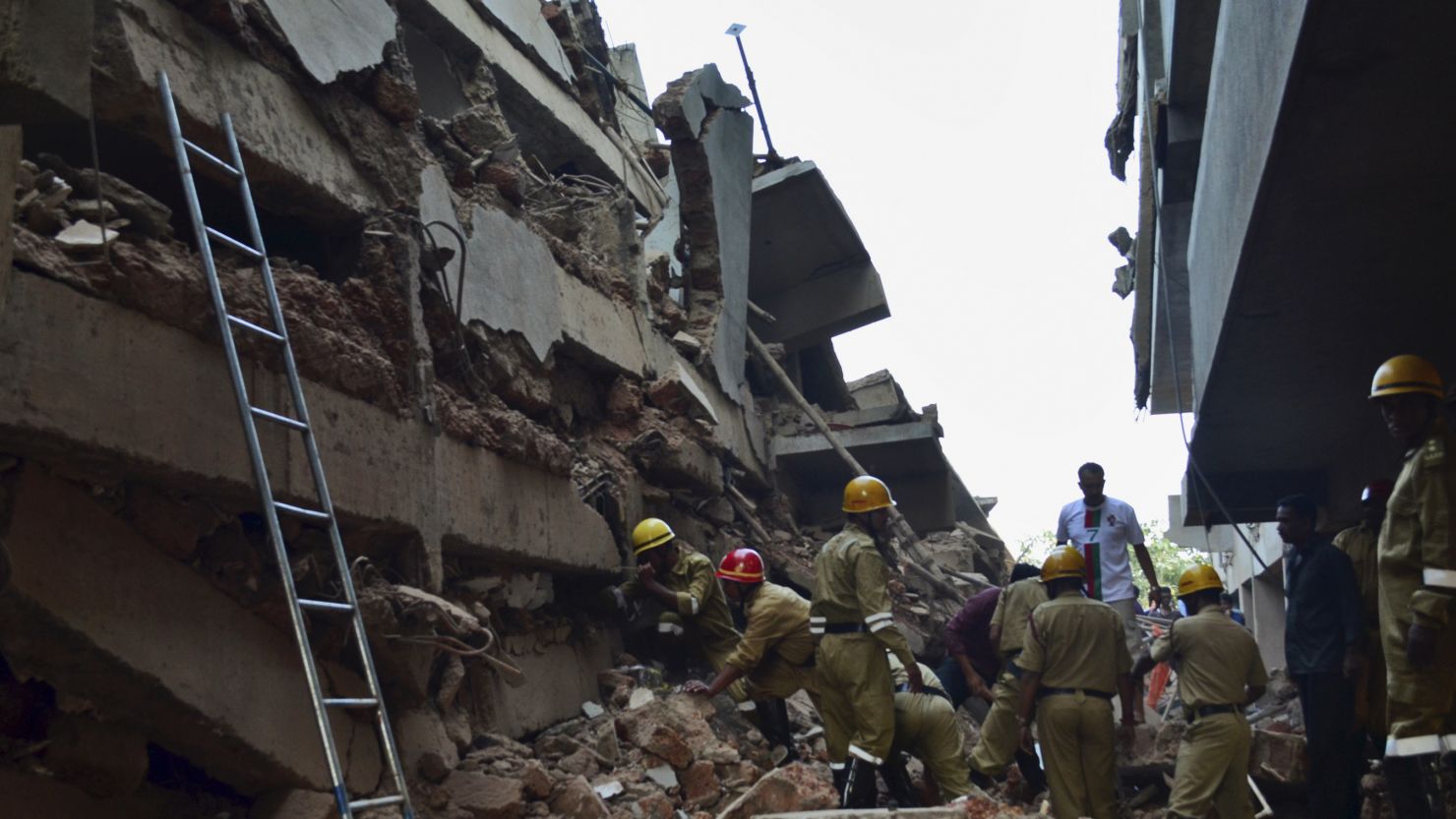 Rescue workers stand amid the debris of a building under construction that collapsed in Goa, India on 5 January. 