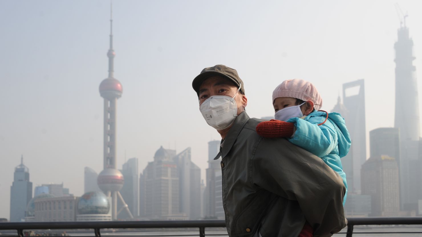  A man and his child wear masks as they visit  Shanghai's Bund on December 25.