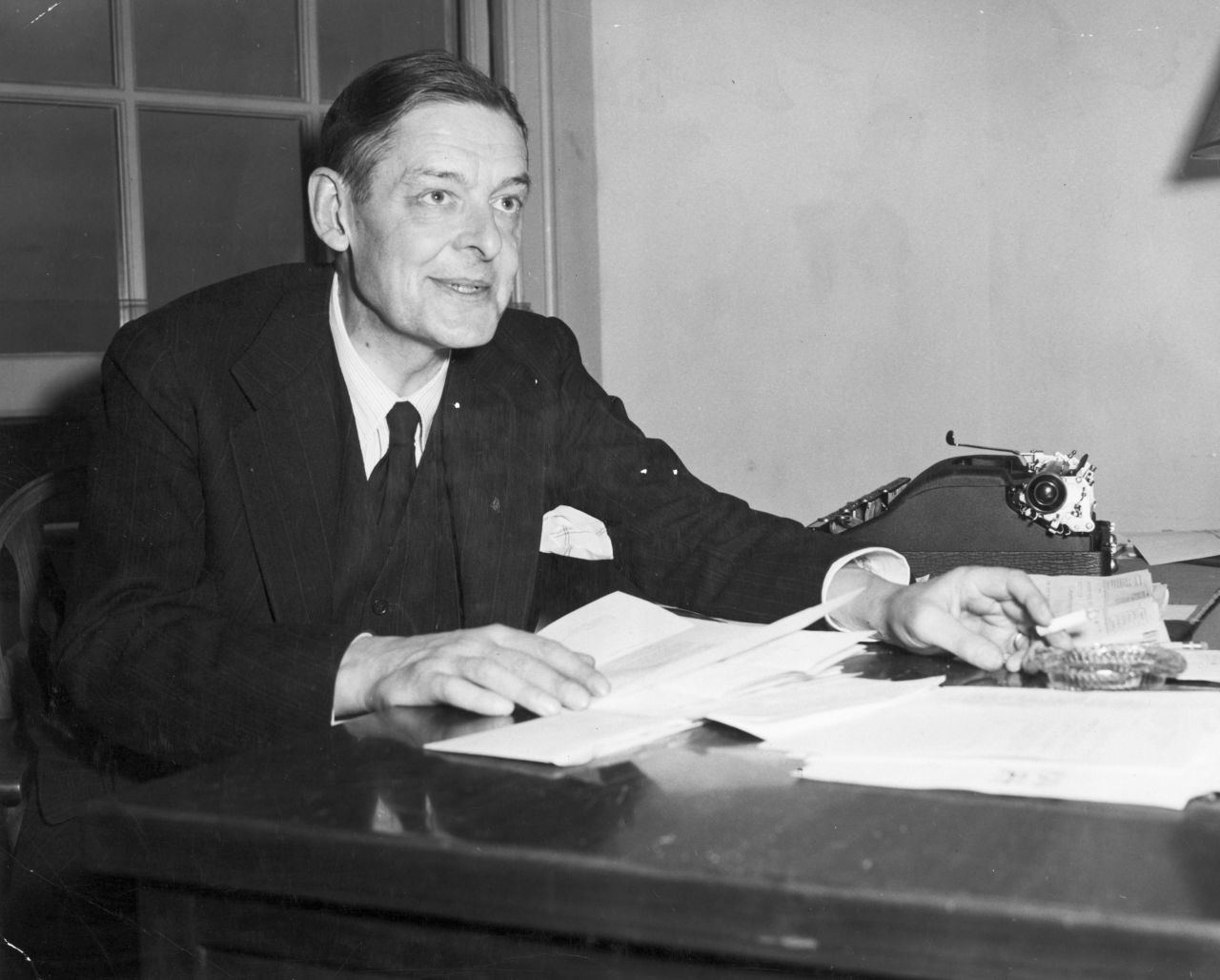 Poet T. S. Eliot inspects manuscripts in this undated photo.