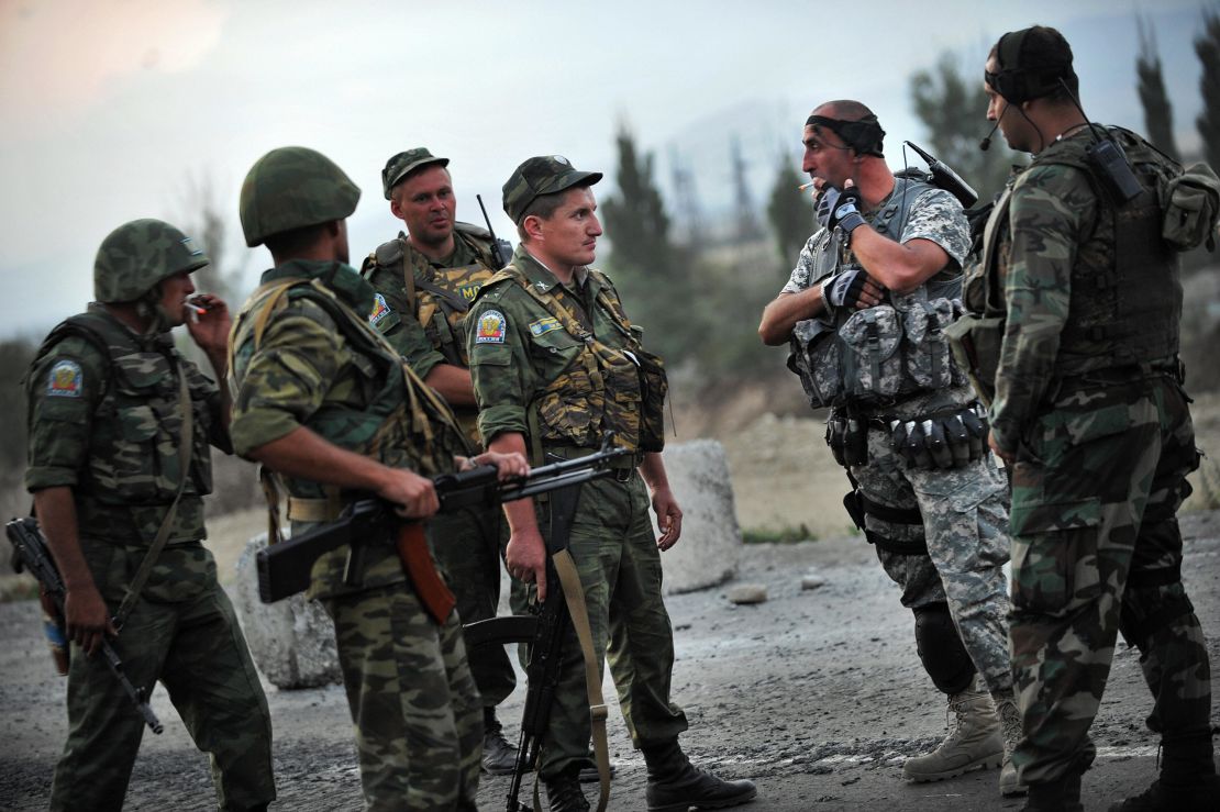 Russian peacekeepers talk with Georgian soldiers near the village of Khurvaleti during the conflict in August 2008.