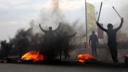 Iraqi Sunni masked protesters burn tires to blocked the main highway to Jordan and Syria, outside Fallujah, 40 miles (65 kilometers) west of Baghdad, Iraq, Monday, Dec. 30, 2013.
