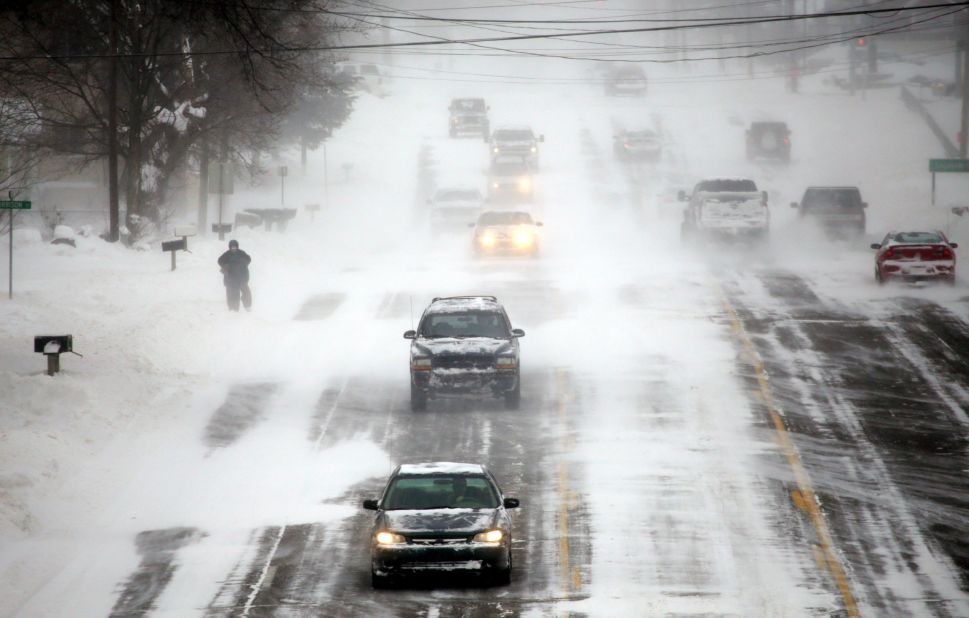 Vehicles drive down a snow-covered road in Burton, Michigan, on January 6.