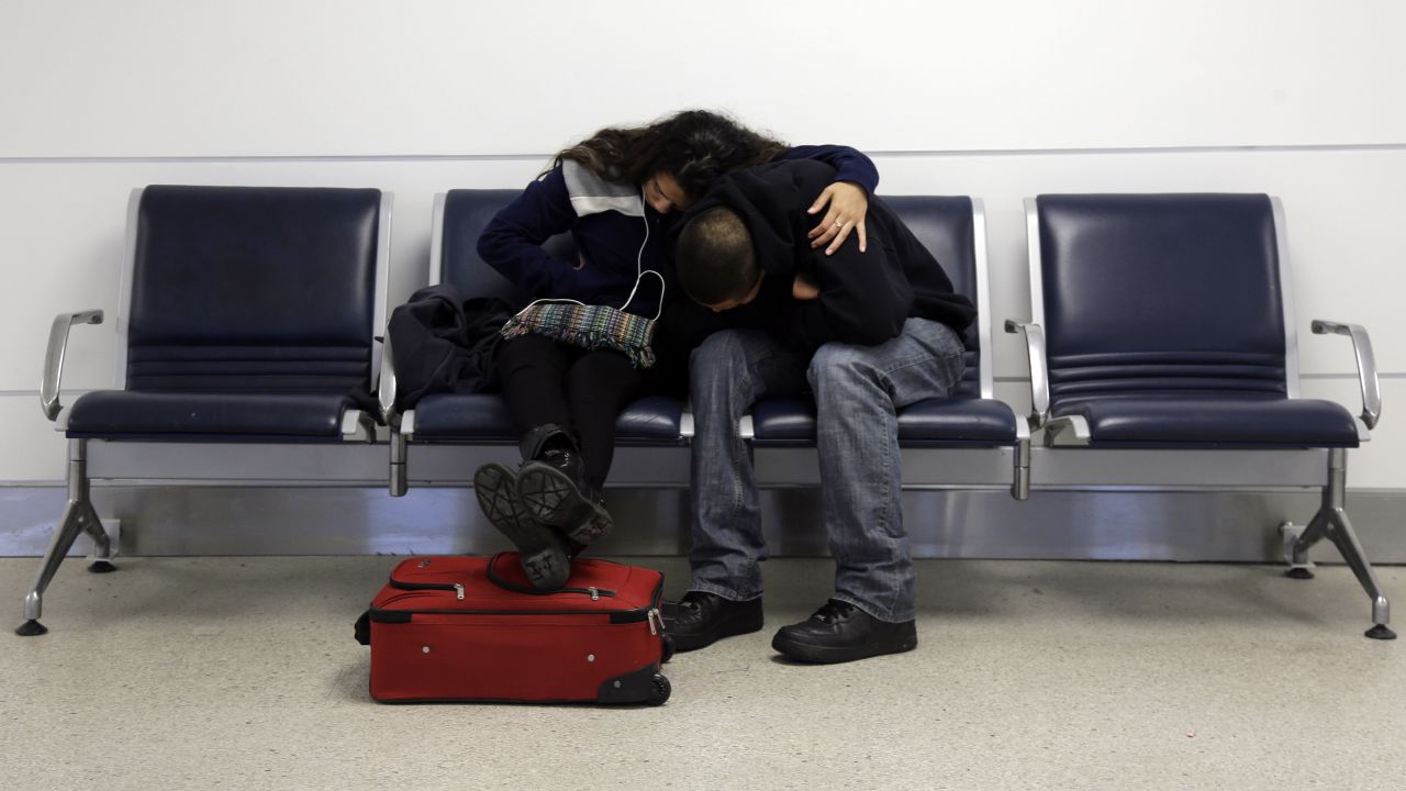 A man and woman do their best to get comfortable while stranded at Lambert-St. Louis International Airport on Sunday, January 5.