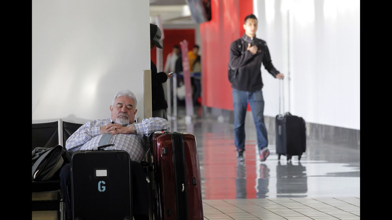 A passenger takes a nap inside Los Angeles International Airport on Friday, January 3, after his flight was canceled because of the weather on the East Coast.