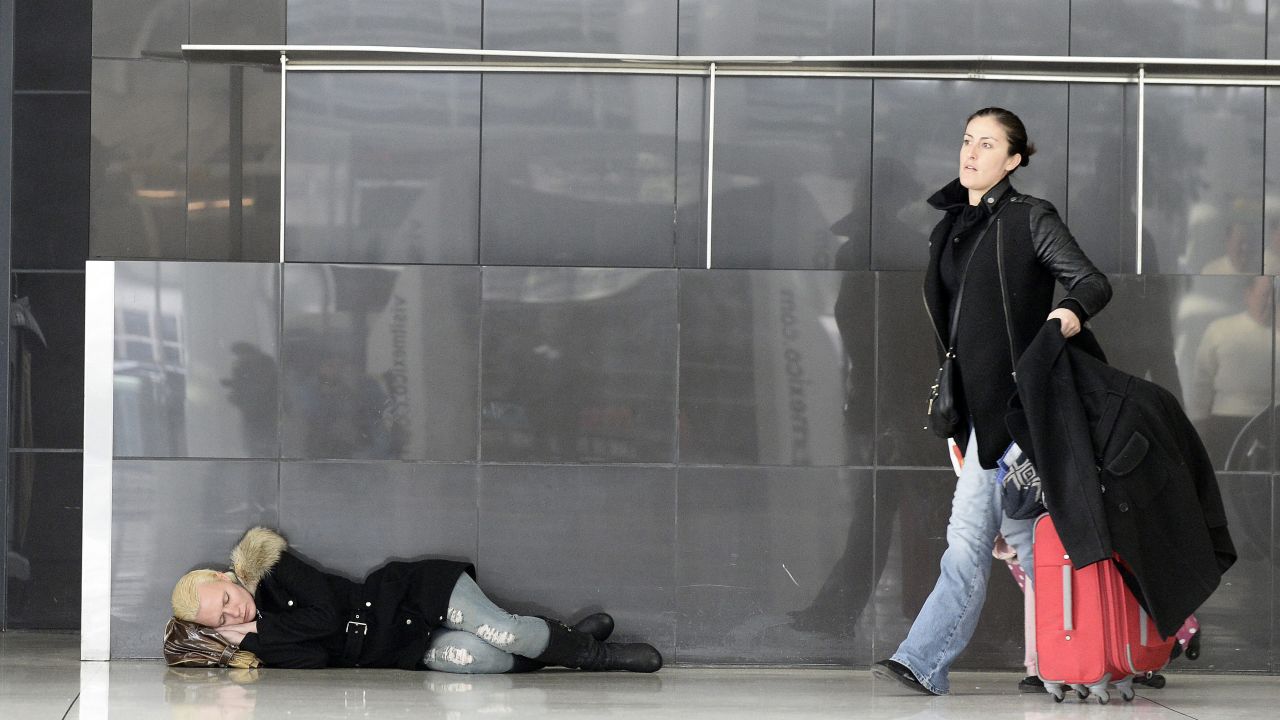 A woman sleeps on the floor of New York's JFK Airport on January 3.