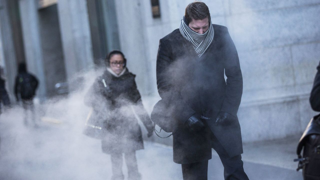A man clenches his fists while walking past a steam vent in New York City on January 7.