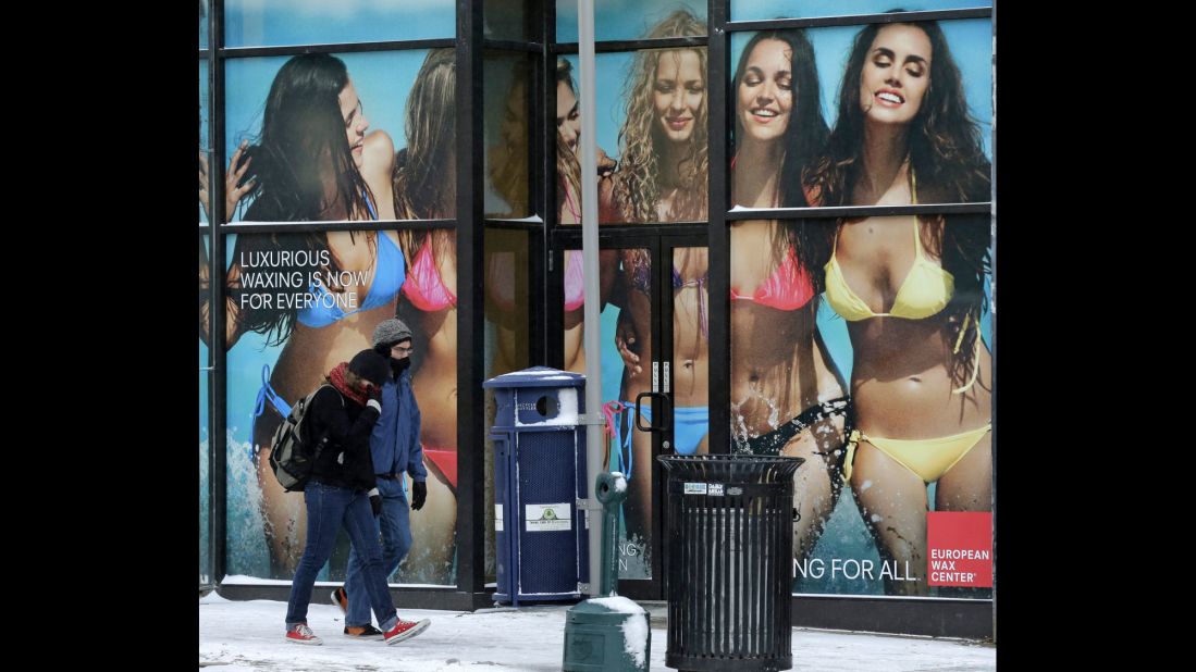 A couple walks past an advertisement in Pittsburgh during sub-zero temperatures January 7.