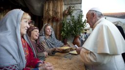 The Pope greats a group of women participating in the nativity scene.
