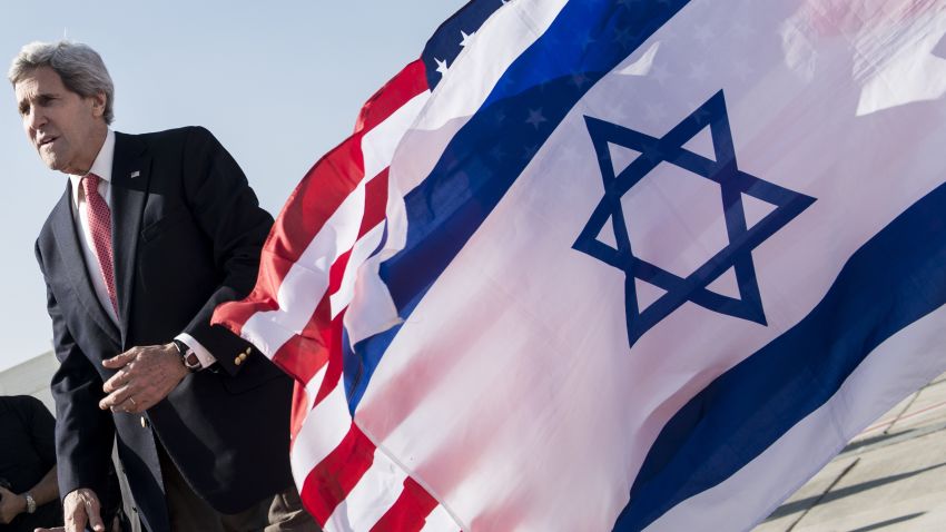 U.S. Secretary of State John Kerry walks past American (back) and Israeli flags at Ben Gurion International Airport in Tel Aviv on January 6, 2014.
