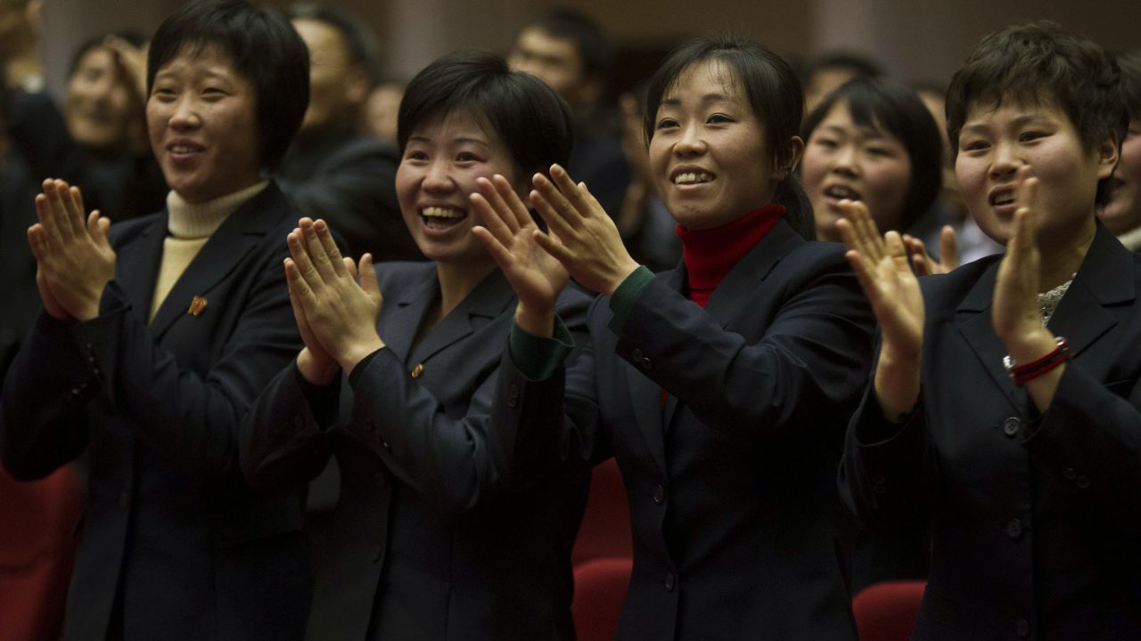 North Koreans applaud at the start of the game.