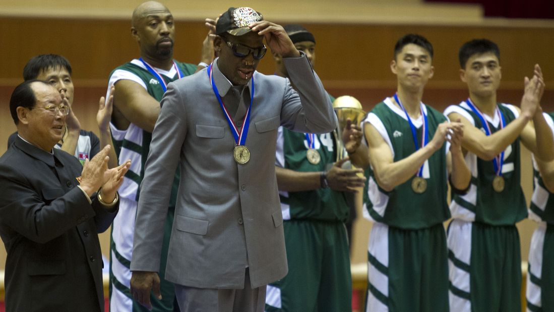 Rodman tips his hat as U.S. and North Korean basketball players applaud at the end of the game.