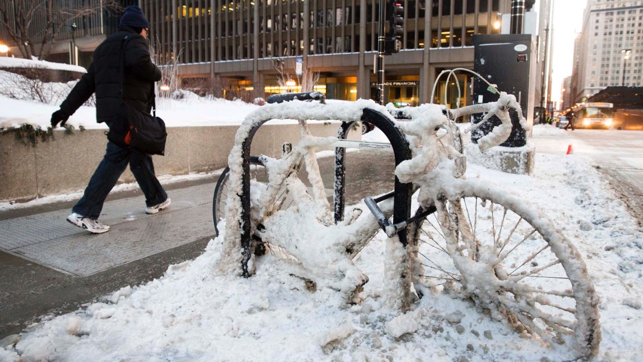 A man walks past a snow-covered bicycle in Chicago on January 7.